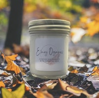 a jar of soy candle surrounded by autumn leaves